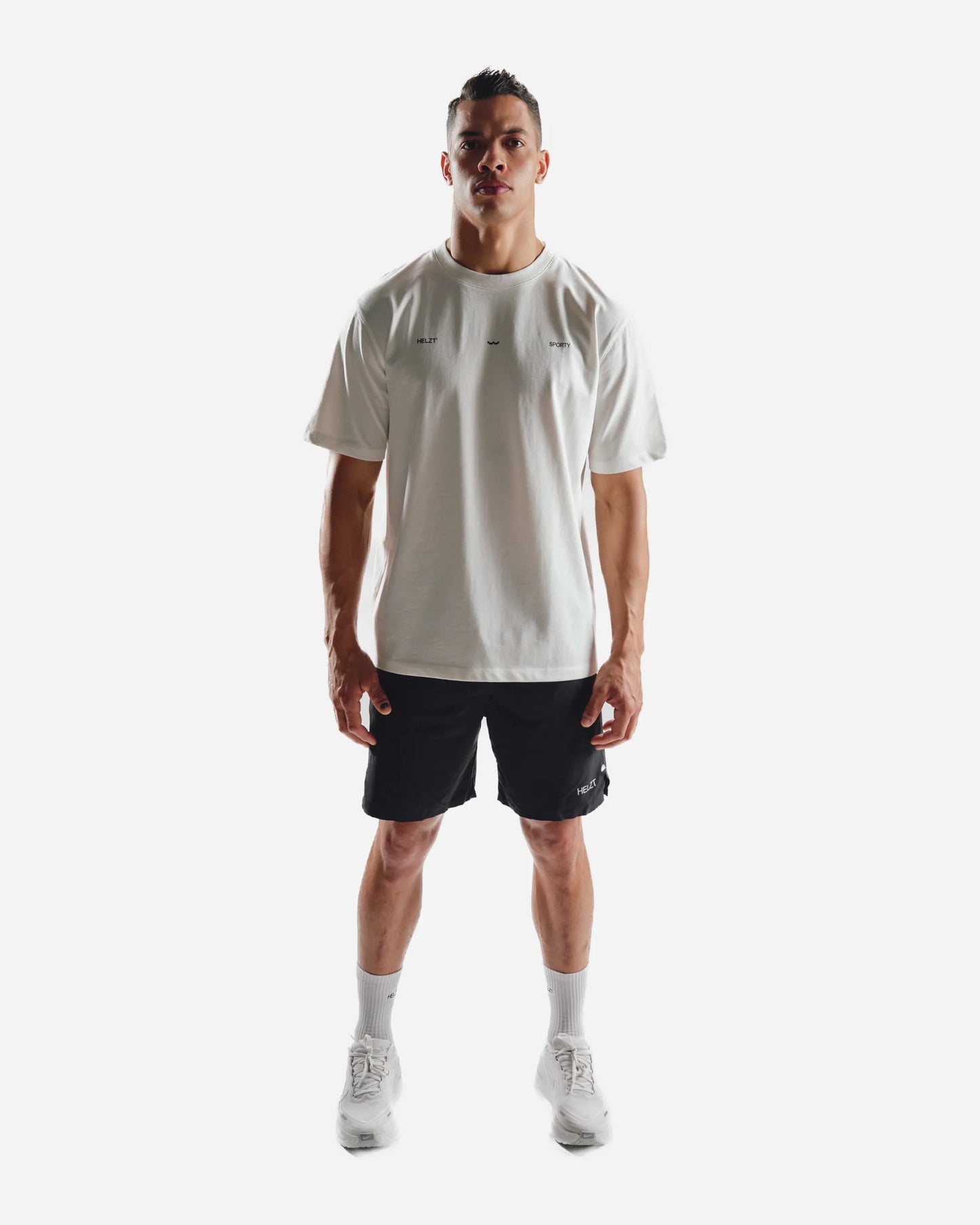 Man wearing a white t-shirt and black shorts on a white background